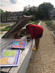 woman in red shirt leanign into a storage bench with signs sitting on top of the neighboring bench